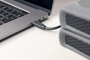 Detail of External hard disk cable connected to a modern laptop computer photo