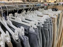 la ropa cuelga en perchas en la tienda. foto