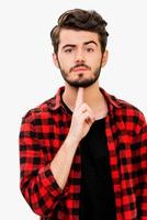 I am fed up. Handsome young man looking at cameraand gesturing handgun while standing against white background photo