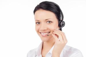 Representante de Servicio al Cliente. bella joven con auriculares sonriendo y mirando a la cámara mientras está aislada en blanco foto