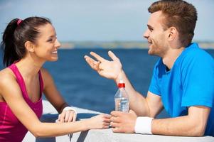 Sport connecting people. Side view of beautiful young couple in sports clothing standing face to face and talking photo