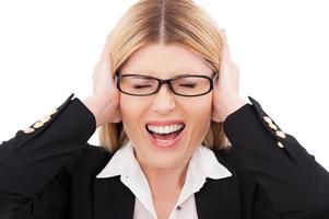 Emotional stress. Depressed mature businesswoman keeping eyes closed and covering ears with hands while standing isolated on white photo