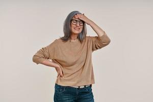 Frustrated mature woman suffering from headache and touching her forehead photo