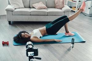 Top view of young fit African woman working out and smiling while making social video photo