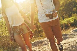 Close up of young loving couple in casual clothing holding hands while walking outdoors photo