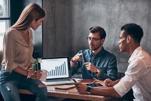 grupo de jóvenes con ropa informal inteligente analizando datos en portátiles foto