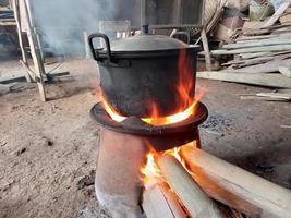 agua para cocinar usando una olla en una estufa de leña tradicional