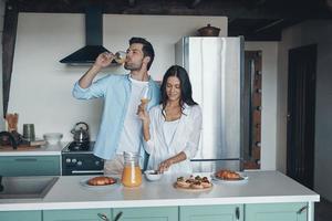 Beautiful young couple preparing breakfast while spending time in the kitchen photo