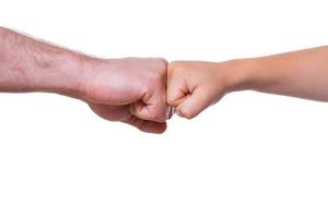 Large and small. Close-up of adult and child fists together and isolated on white photo
