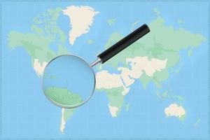 Map of the world with a magnifying glass on a map of Barbados. vector