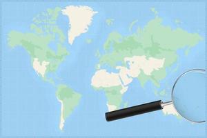 Map of the world with a magnifying glass on a map of Tuvalu. vector