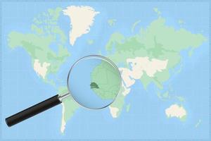 Map of the world with a magnifying glass on a map of Senegal. vector