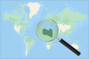 Map of the world with a magnifying glass on a map of Libya. vector