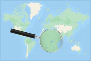 Map of the world with a magnifying glass on a map of Rwanda. vector