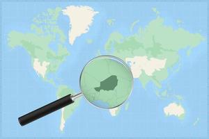 Map of the world with a magnifying glass on a map of Niger. vector