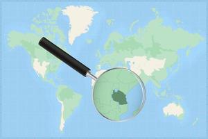 Map of the world with a magnifying glass on a map of Tanzania. vector