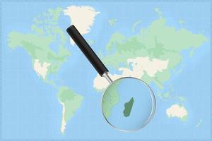 Map of the world with a magnifying glass on a map of Madagascar. vector