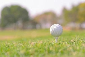 A closeup shot of a white golf ball in a course photo