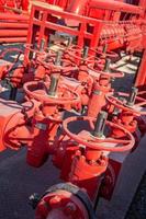un primer plano de las válvulas de un oleoducto industrial rojo foto