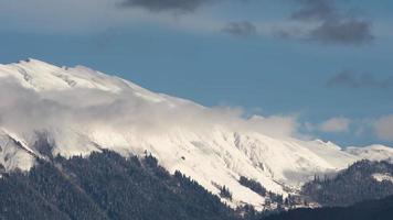 timelapse sur un paysage de sommets enneigés et de ciel avec des nuages blancs. panorama de montagne et ciel bleu. nature montagnes du caucase video