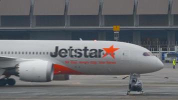 phuket, thailand 3. dezember 2016 - jetstar boeing 787 dreamliner vh vka rollt nach der landung am flughafen phuket. regnerisches Wetter video