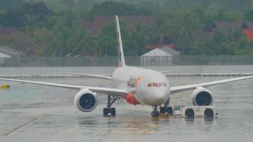 phuket, tailândia, 3 de dezembro de 2016 - jetstar boeing 787 dreamliner vh vka no avental antes da partida no aeroporto de phuket. tempo chuvoso video