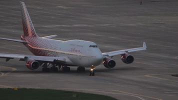 sochi, ryssland juli 29, 2022 - boeing 747 av rossiya taxning till de terminal efter landning på sochi flygplats. jumbo jet på de flygfält. lysa skarpt av de Sol glöd på styrelse de plan video