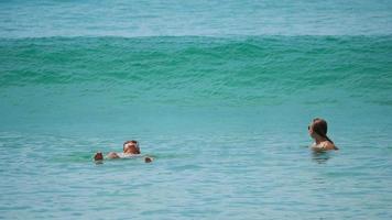 phuket, Thailand november 20, 2018 - vrouw en Mens zwemmen in Open zee genieten van zomer vakantie en bewonderend toneel- zeegezicht. meisje en jongen ontspannende Aan exotisch toevlucht drijvend in azuur Doorzichtig water. video