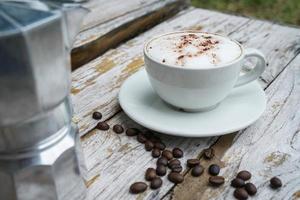 capuchino caliente en taza blanca con fondo de madera, el café es una bebida popular en todo el mundo. foto