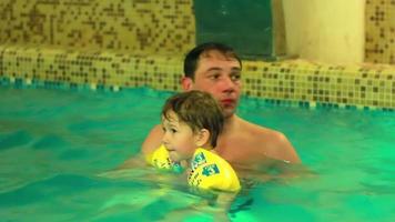 Family having fun in an indoor pool video