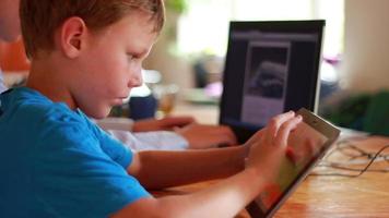 twee broers gebruik makend van laptop en ipod Aan tafel Bij huis video