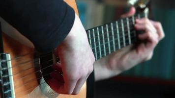 main humaine jouant sur les cordes de la guitare video