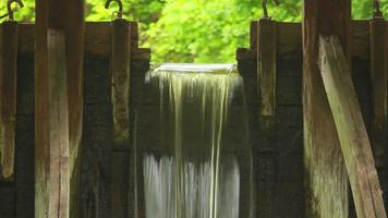 Water flows over old wooden dam video