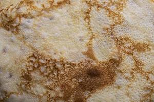 Pancake surface texture and pattern. Close-up of thin hot pancakes in a plate. Traditional rustic food. Graphic resource. photo