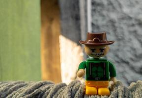 October 2022, Jakarta Indonesia, minifigure toy against a background of a blurred wall and a wooden fence in the sun photo