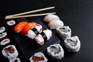 comida japonesa de sushi. maki ands rolls con atún, salmón, camarones, cangrejo y aguacate. vista superior de sushi variado. foto