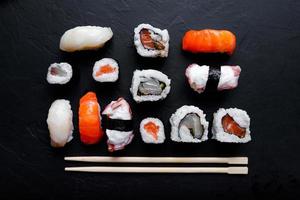 comida japonesa de sushi. maki ands rolls con atún, salmón, camarones, cangrejo y aguacate. vista superior de sushi variado. foto