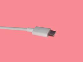 conector usb-c o usb tipo c con cable aislado sobre fondo rosa. foto