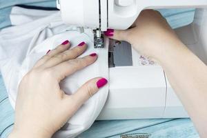 Hands on the sewing machine photo