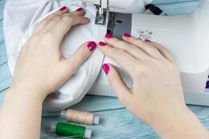 Hands on the sewing machine photo