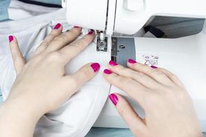 Hands on the sewing machine photo
