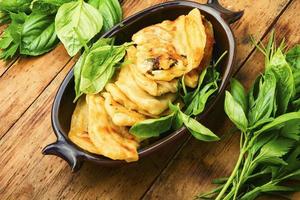 Tasty Azerbaijani qutab with young greens,wooden table photo