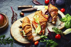 Croissant sandwich with meat and fish filling photo