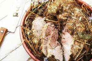 Roast pork in hay with herbs photo