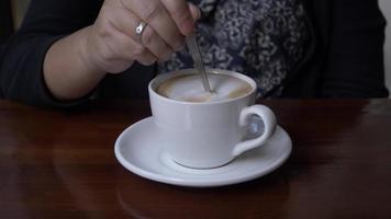 dichtbij omhoog van vrouw hand- roeren koffie video