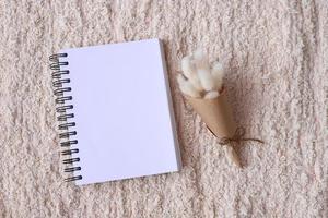 cuaderno en blanco con flores secas foto