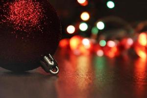 primer plano de la bola de navidad contra el fondo de las luces multicolores de la ciudad. concepto de navidad, año nuevo. fondo borroso foto