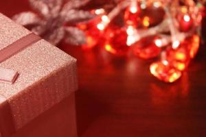 Gift box close-up on the background of a Christmas garland. Concept of christmas, new year. Blurred background, out of focus. photo