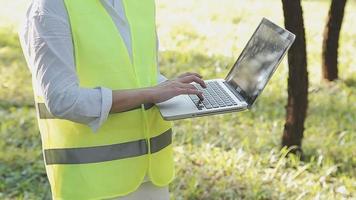 intelligenter asiatischer arbeiter oder männlicher bauingenieur mit schutzhelm und reflektierender weste mit digitalem tablet zur projektplanung und prüfung der bauzeichnung auf der baustelle. video