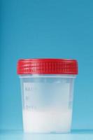 Semen in a test container with a red lid on a blue background. photo